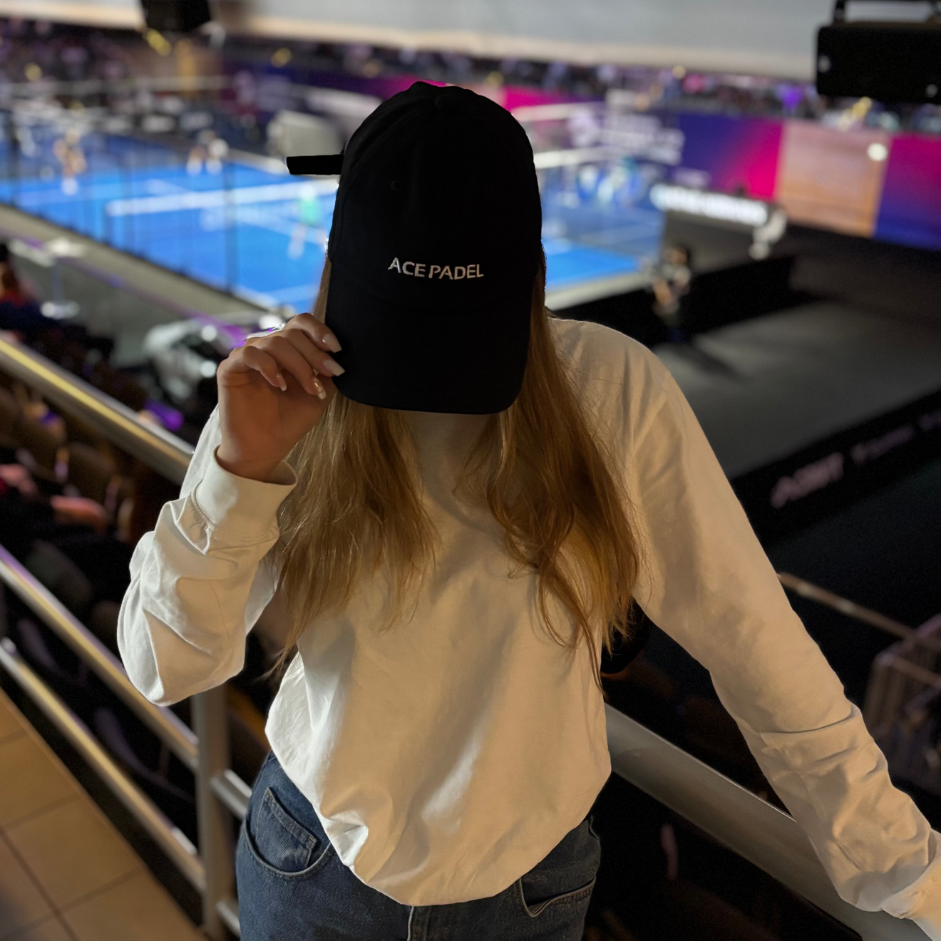 Frau mit ACE PADEL Cap in einer Padel Arena